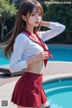 a woman in a school uniform posing by a pool