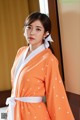 a woman wearing an orange polka dot kimono