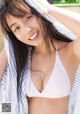 A woman in a white bikini posing for a picture.