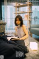 A woman sitting on the floor reading a book.