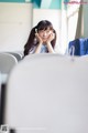 A young woman sitting at a table with her hand on her chin.