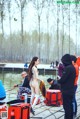 A woman in a bikini standing on a dock next to a body of water.