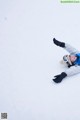 A person laying in the snow with their arms outstretched.