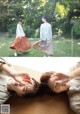 A couple of women laying on top of a wooden table.