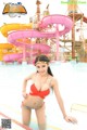 A woman in a red bikini standing in a water park.