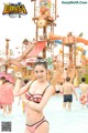 A woman in a pink bikini standing in a water park.